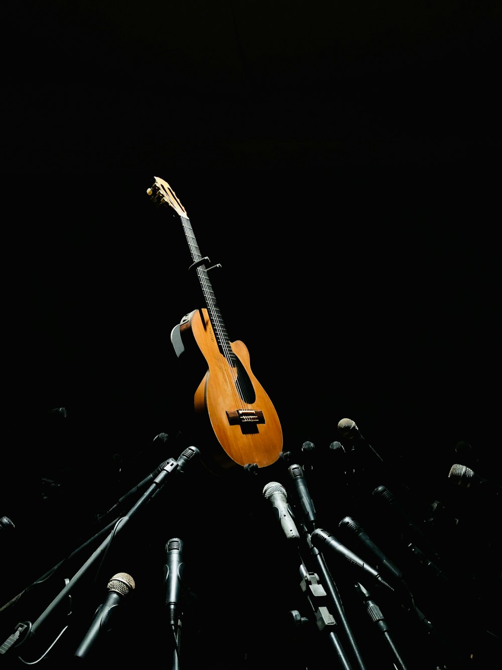 Eine Gitarre ist umgeben von Mikrofonen und Mikrofonköpfen