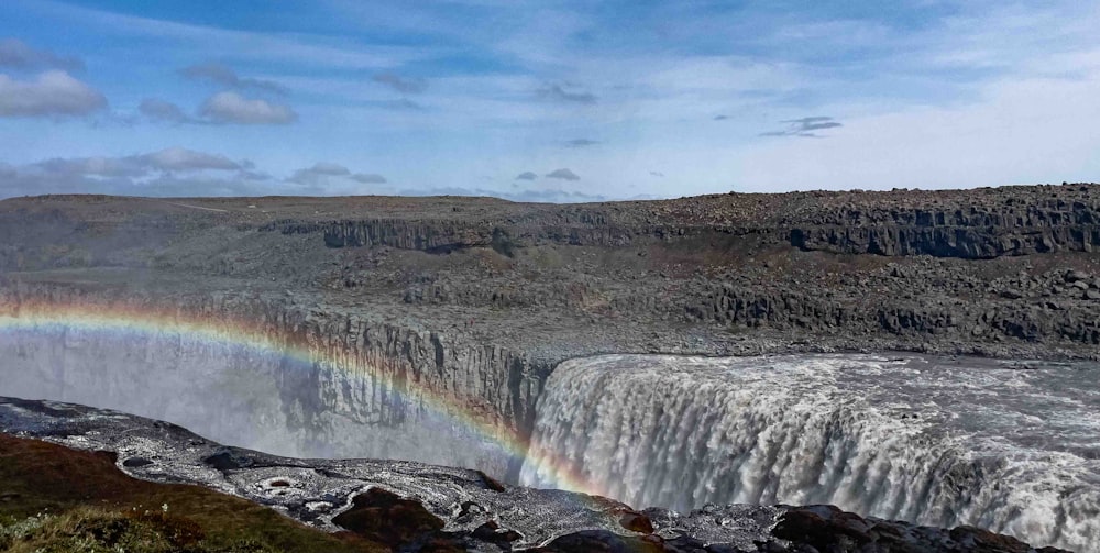 a waterfall with a rainbow in the middle of it