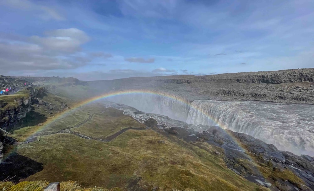 a rainbow in the sky over a waterfall