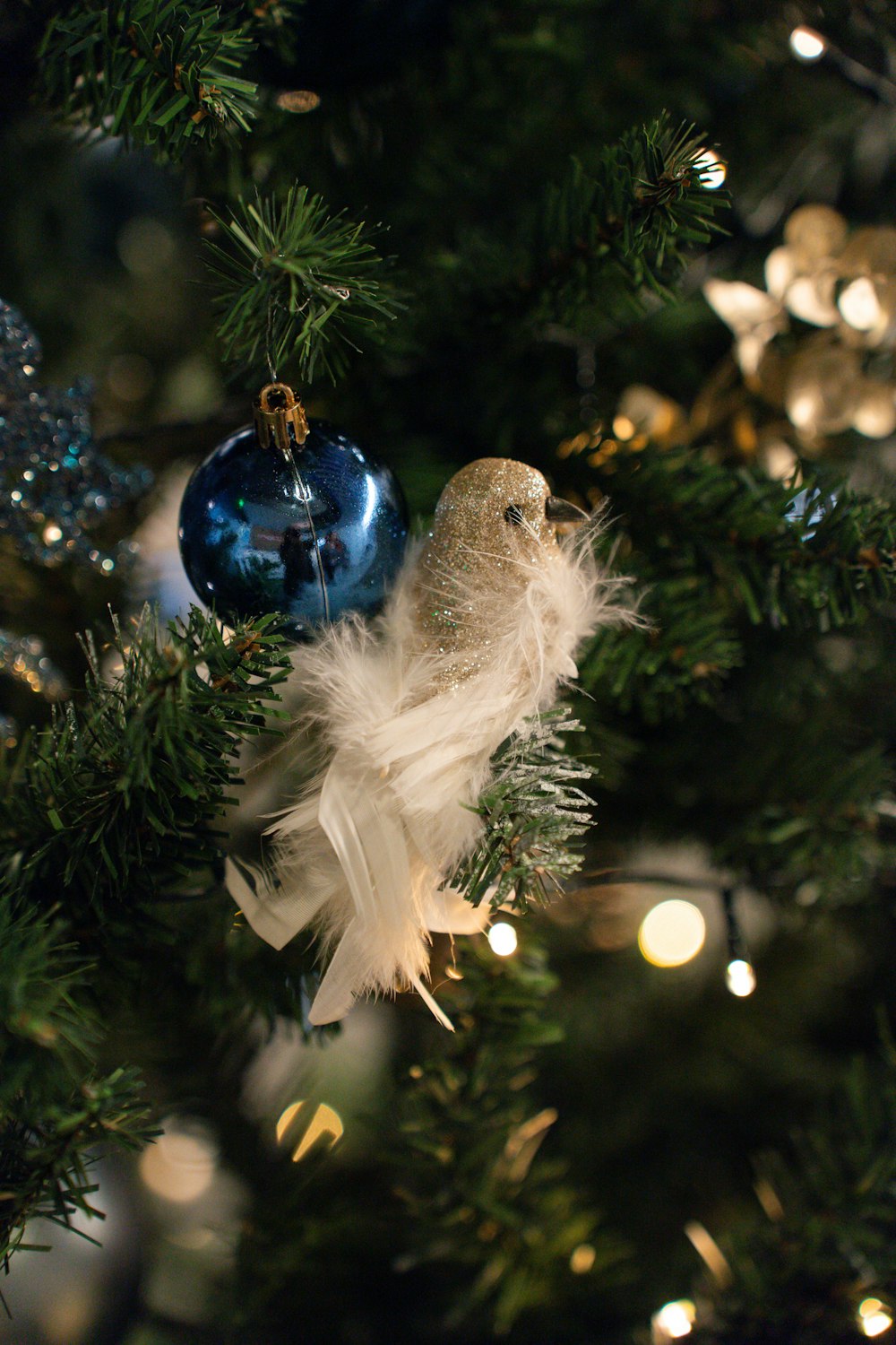 a bird ornament hanging from a christmas tree
