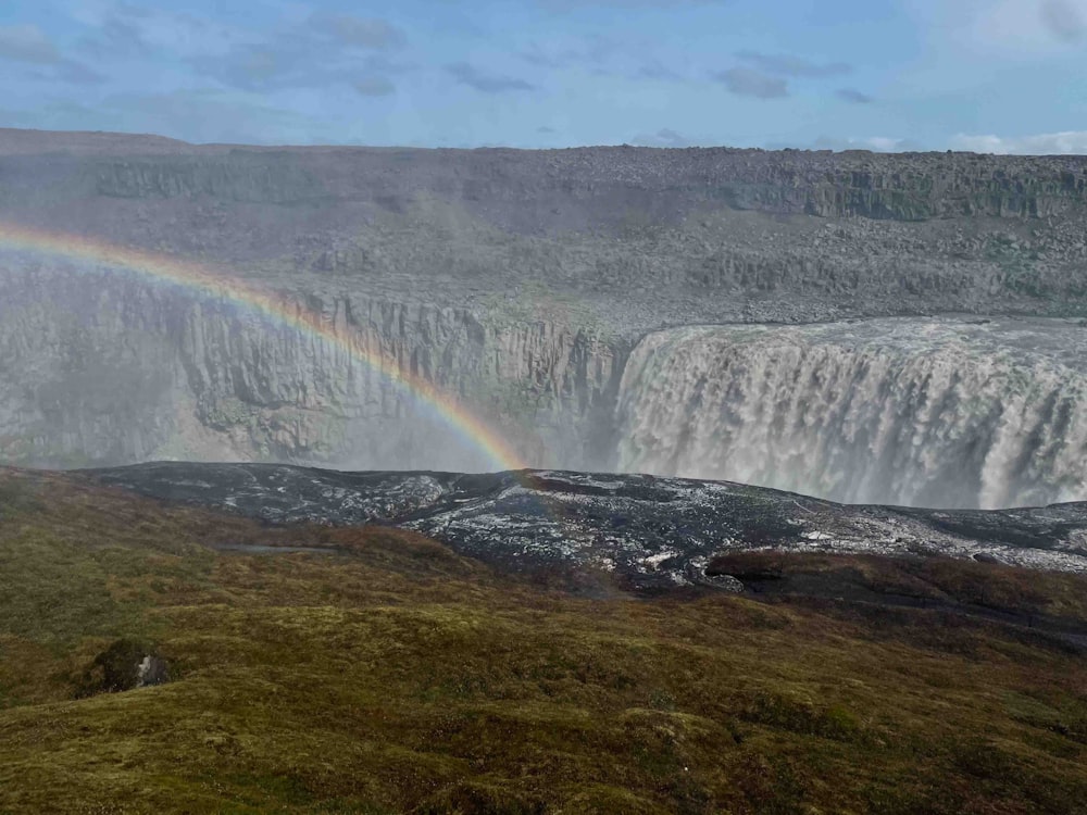 um arco-íris no céu sobre uma cachoeira