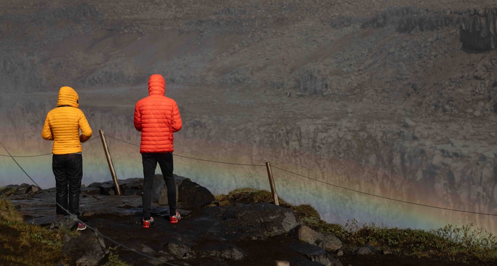 a couple of people standing on top of a mountain