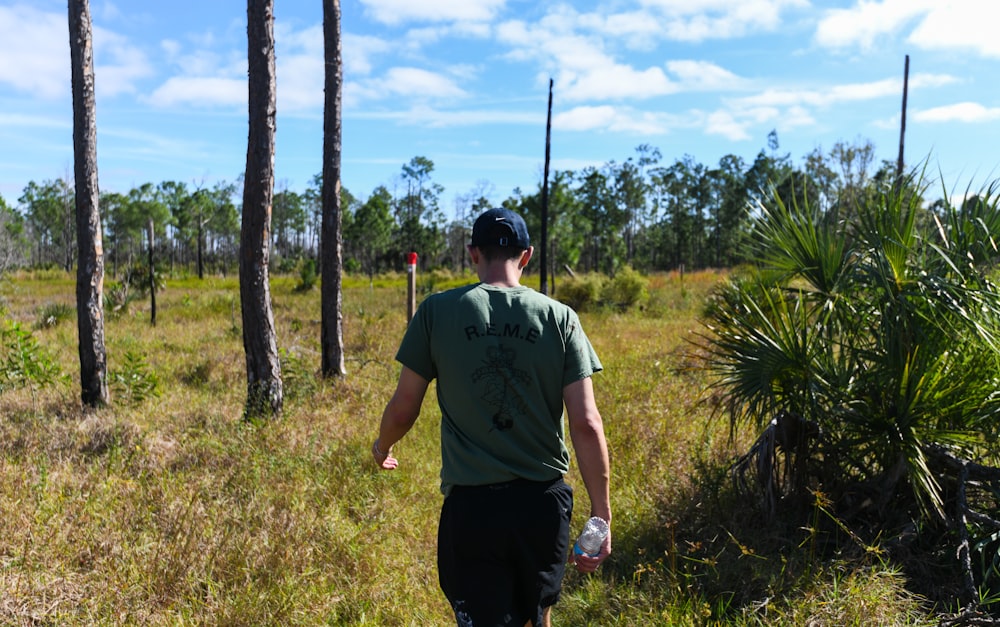 a man walking through a lush green forest