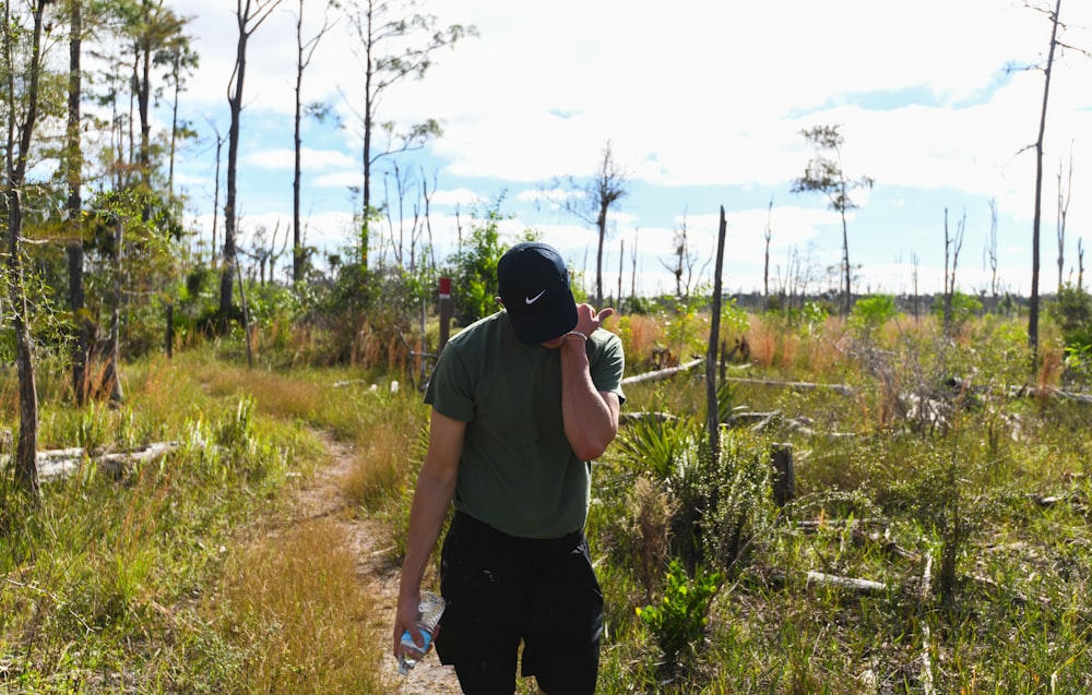 Un hombre caminando por un camino de tierra a través de un bosque