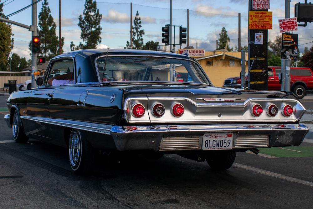 a classic car is parked on the side of the road