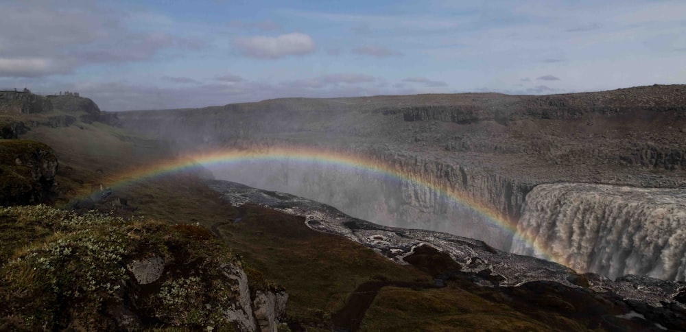 a rainbow in the sky over a waterfall