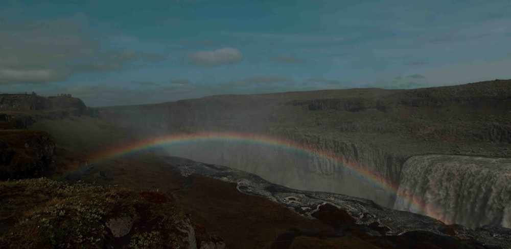 a rainbow in the sky over a waterfall