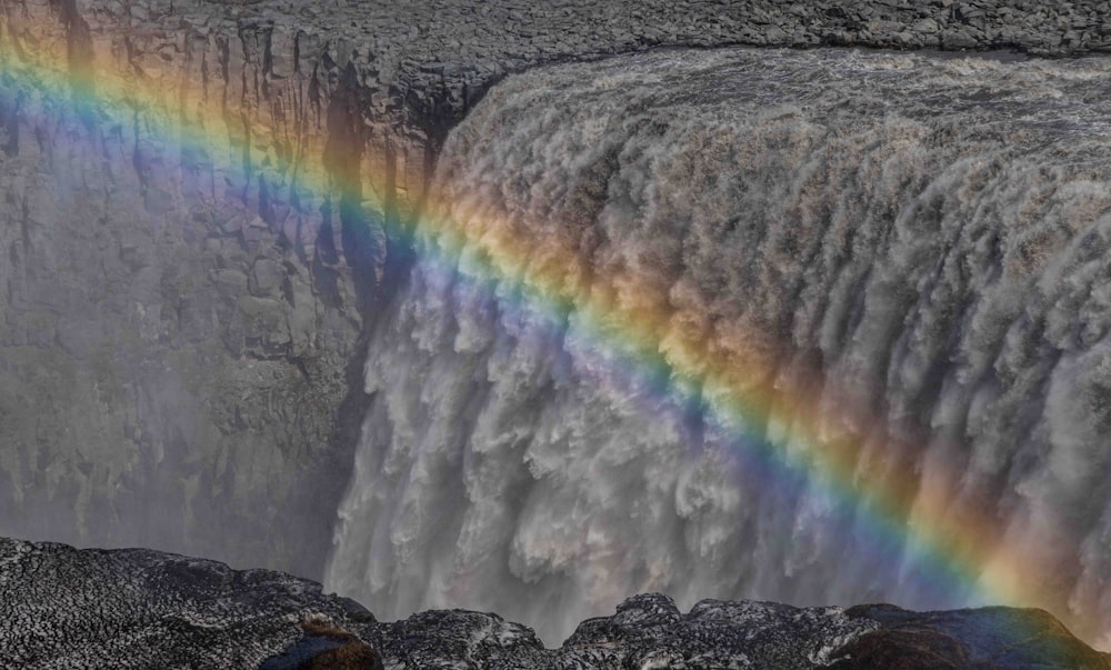 a waterfall with a rainbow in the middle of it