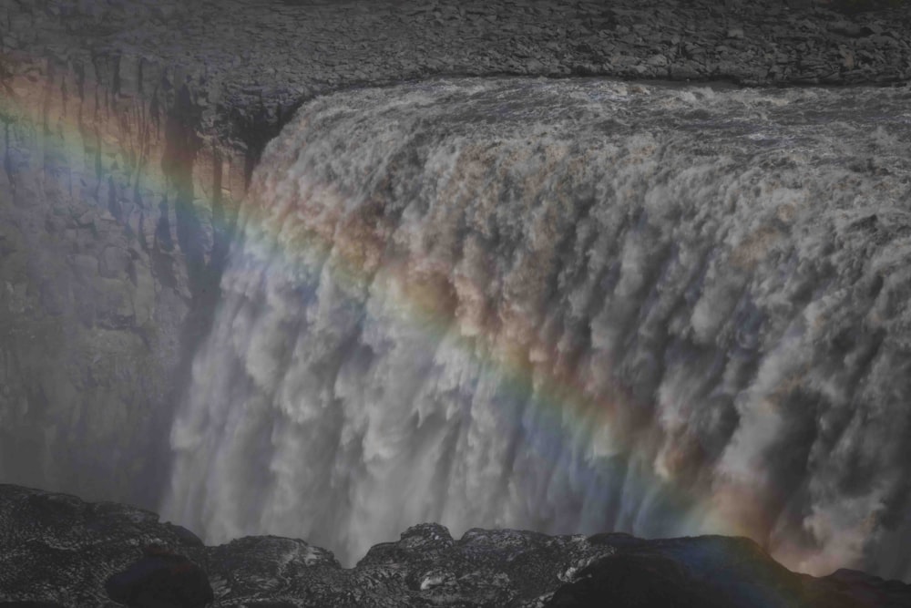 um arco-íris no céu sobre uma cachoeira