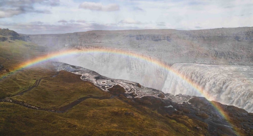 a rainbow in the sky over a waterfall