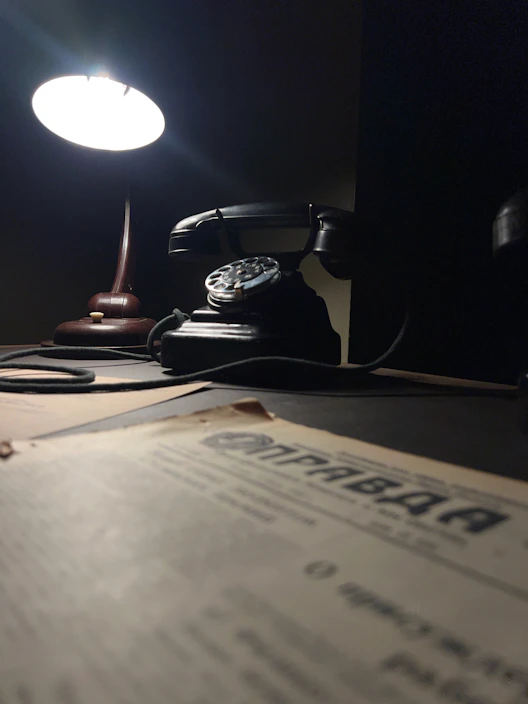 Close-up of a sleek, modern office telephone on a wooden desk.