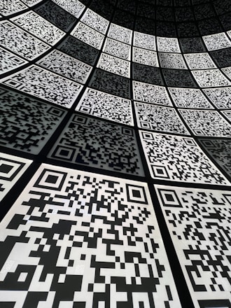 Flat lay of colorful QR codes printed on various marketing materials on a wooden table.