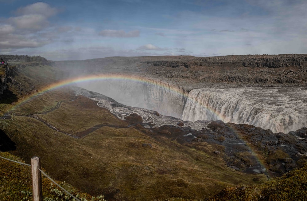 a rainbow in the sky over a waterfall