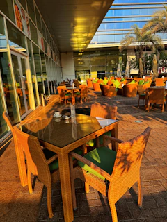Outdoor seating area of Brisacafé with green plants and sunlight.