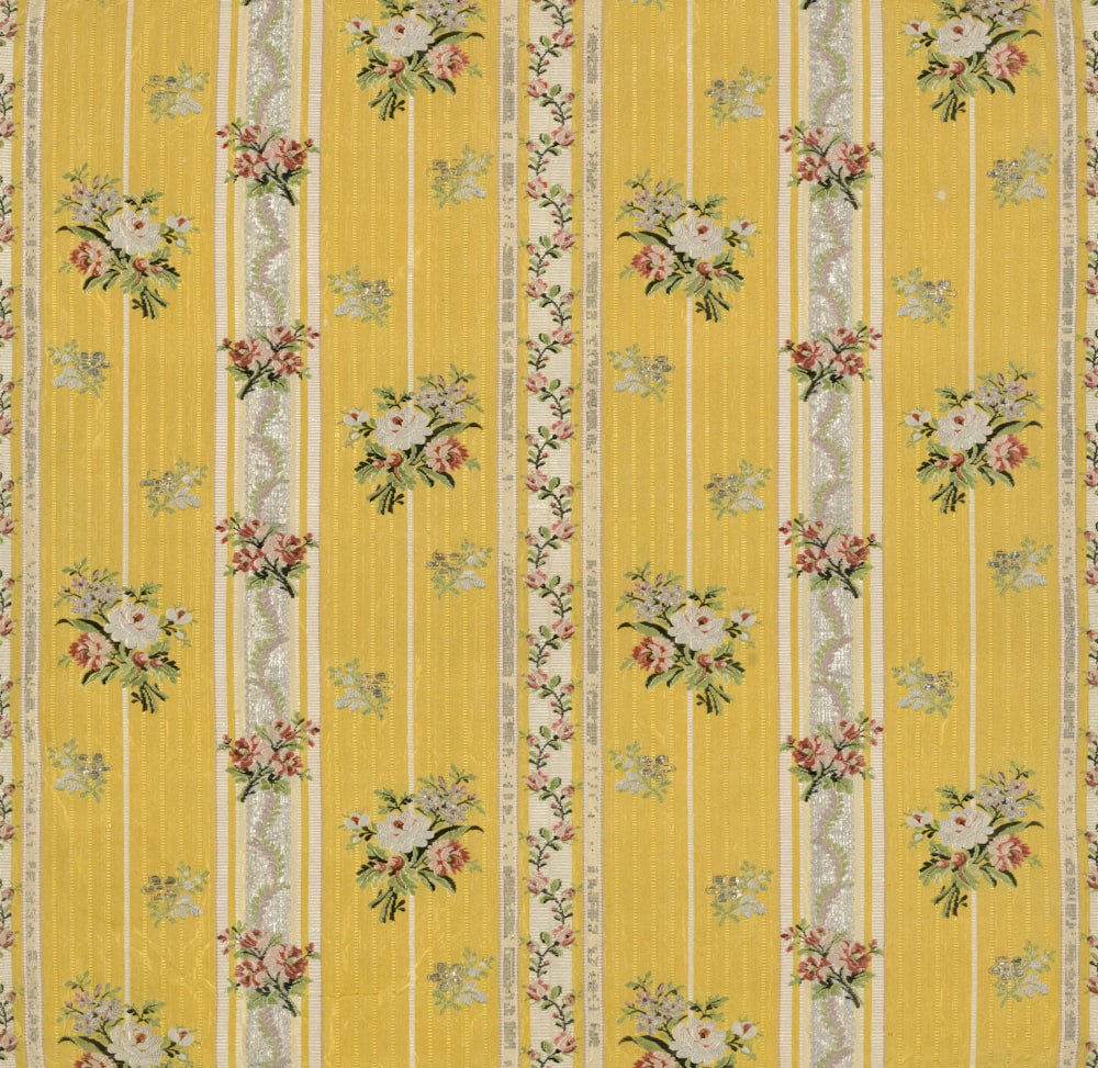 a yellow wallpaper with flowers and stripes