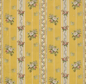 A floral patterned wallpaper featuring vertical yellow stripes with intricate floral bouquets and decorative elements in between. The flowers are arranged in small clusters with colors including white, pink, and green, adding a vintage charm to the design.