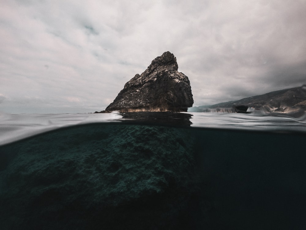 a large rock sticking out of the water