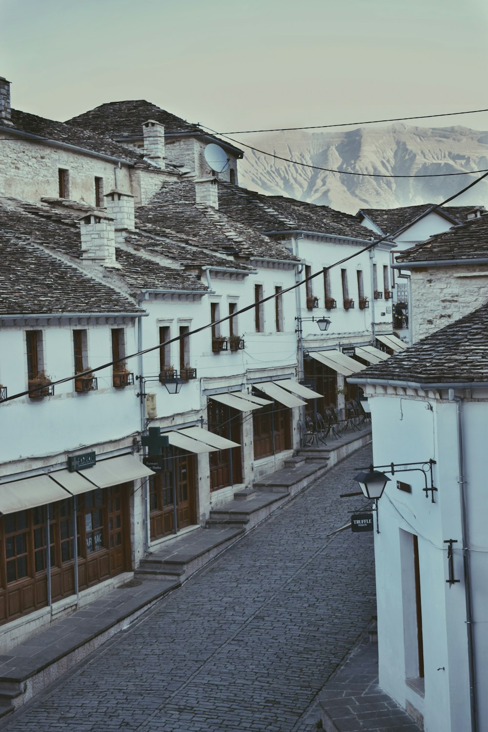 a cobblestone street lined with white buildings