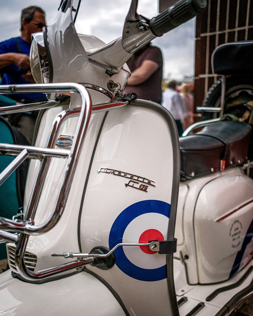 a white motor scooter parked next to a building