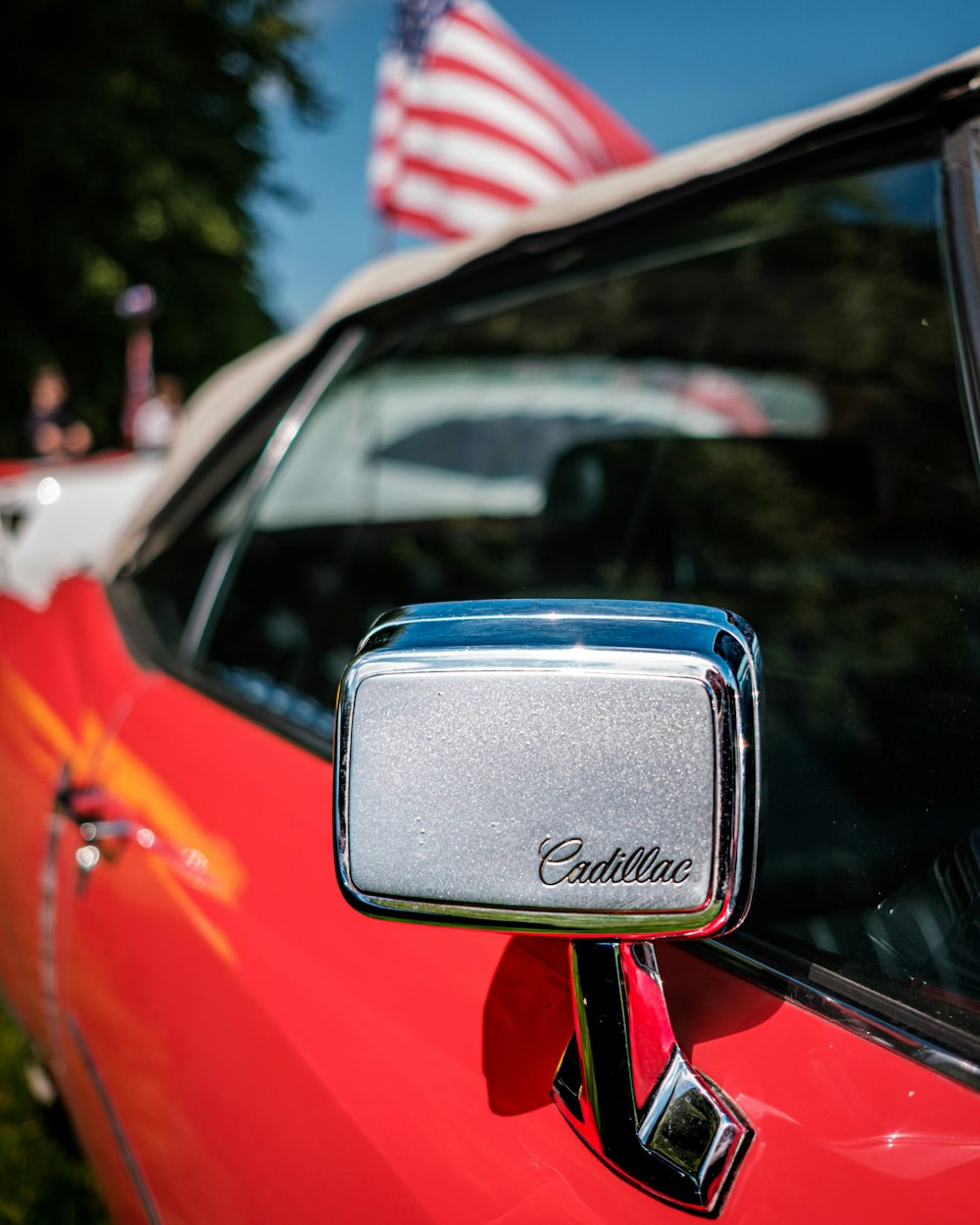 a red car with an american flag in the background