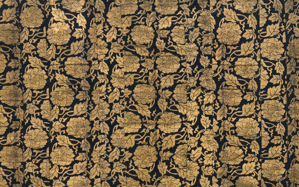 a black and gold wallpaper with a floral design