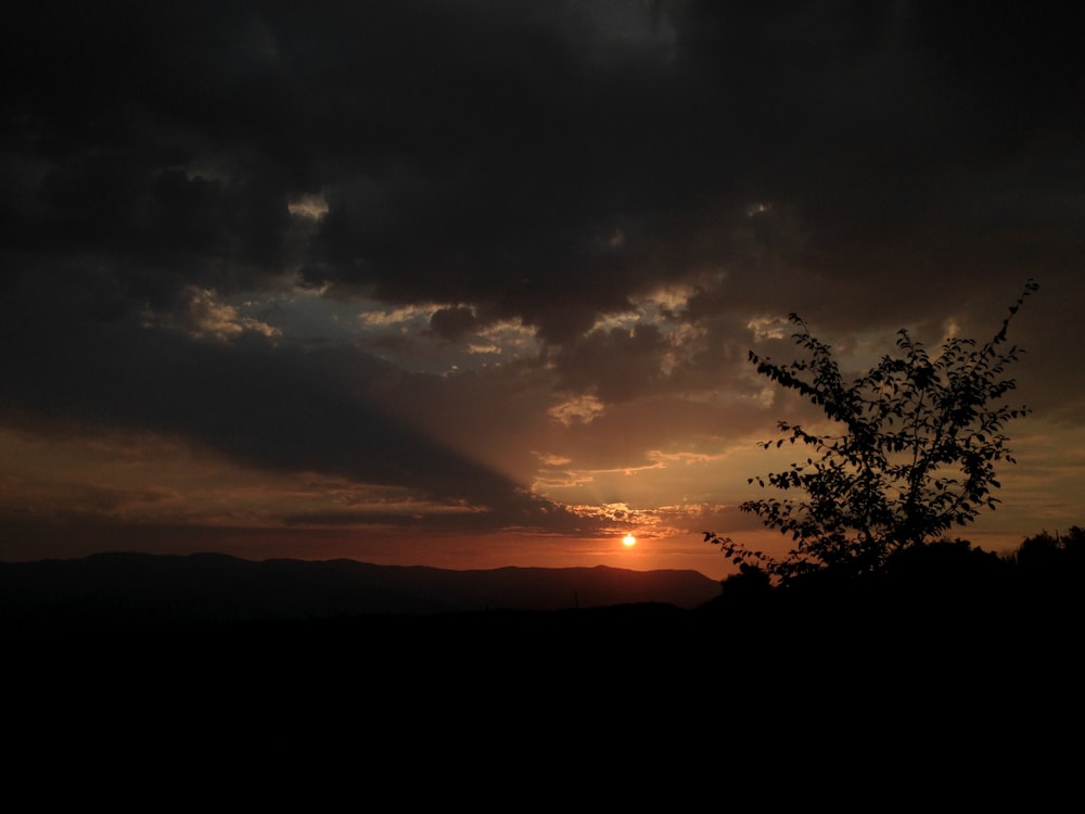 the sun is setting over a mountain range