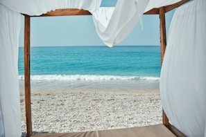 A serene beach destination with a private cabana and sunset view.