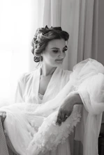 Close-up of a confident woman smiling, wearing a delicate silk robe.