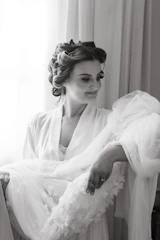 A friendly technician carefully inspecting a delicate silk blouse under soft lighting.