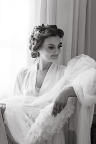 A woman smiling confidently while holding a delicate lace accessory.