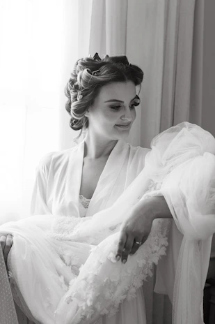 A cozy scene of a woman enjoying a moment of self-care, surrounded by elegant fashion pieces and soft natural light