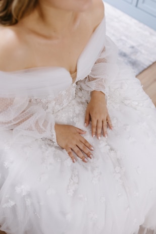 Close-up of a delicate wedding dress being carefully cleaned by hand.