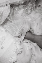 Close-up of intricate bead and lace embroidery on a luxurious fabric, showcasing detailed craftsmanship.