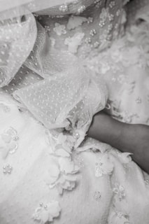 Close-up of a delicate haute couture gown with intricate embroidery in soft rose tones