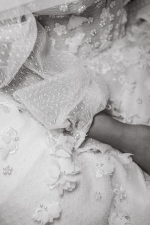 Close-up of intricate lace fabric draped elegantly over soft satin.