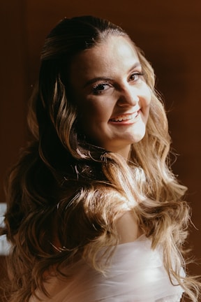 Woman smiling with long, flowing hair extensions styled in soft waves.