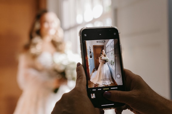 A professional photographer capturing a candid wedding moment in natural light.