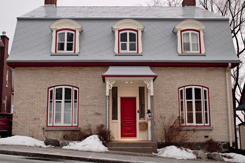 a small brick house with a red door