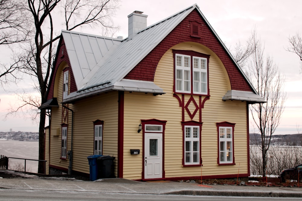 a yellow and red house with a white roof