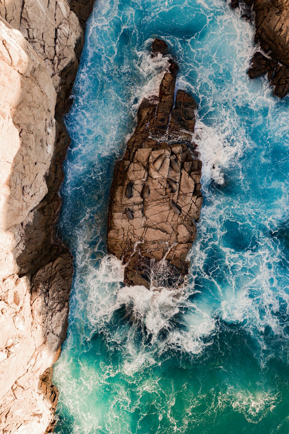 an aerial view of a rock formation in the ocean