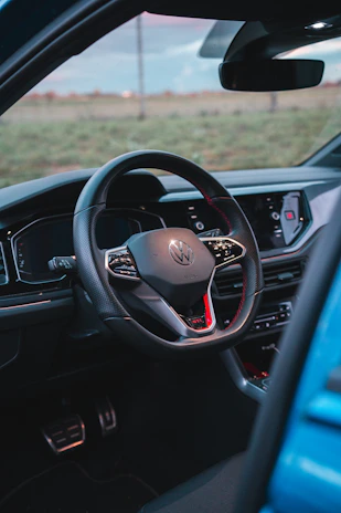 A close-up of a car’s dashboard and steering wheel, showing a well-kept interior.