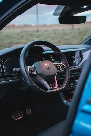 A close-up of a shiny dashboard and steering wheel inside a well-maintained used car.