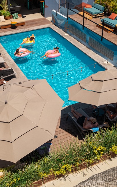 a couple of umbrellas that are by a pool