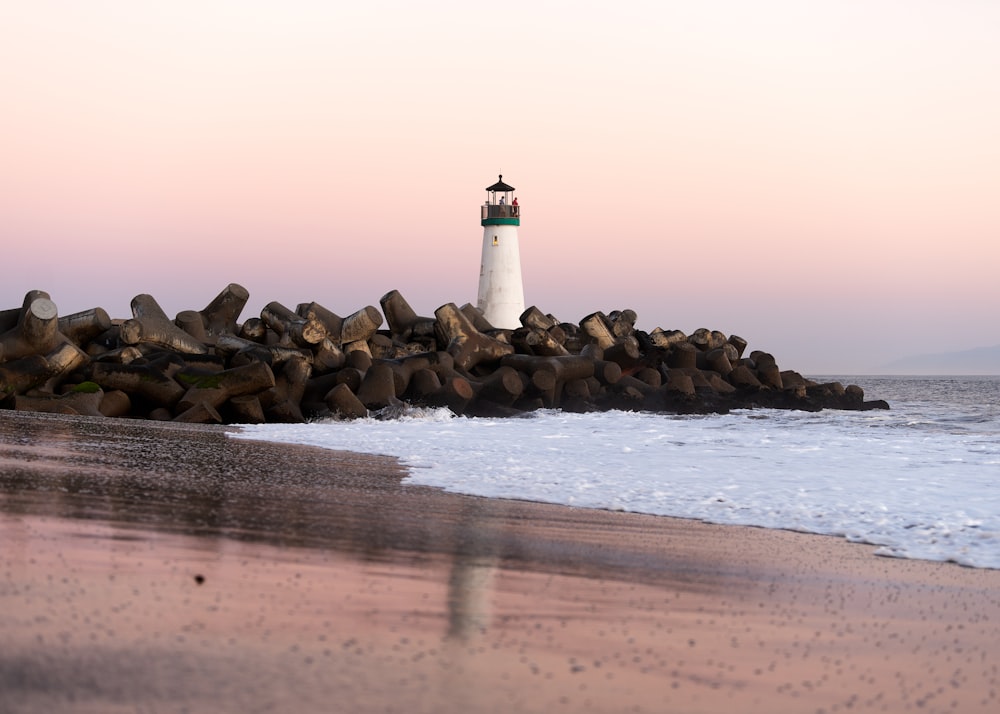 a light house sitting on top of a rocky beach