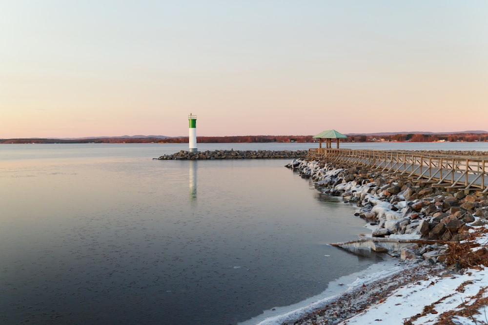 a body of water with a light house in the distance