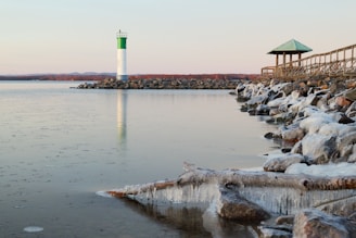 a large body of water with a light house in the background