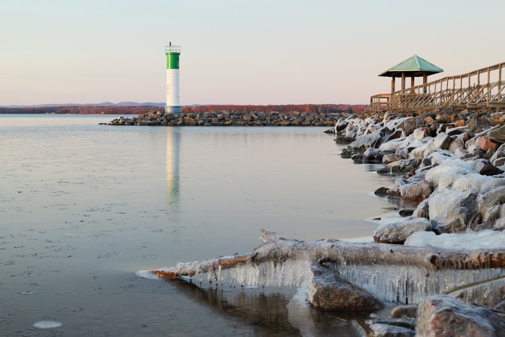 a large body of water with a light house in the background