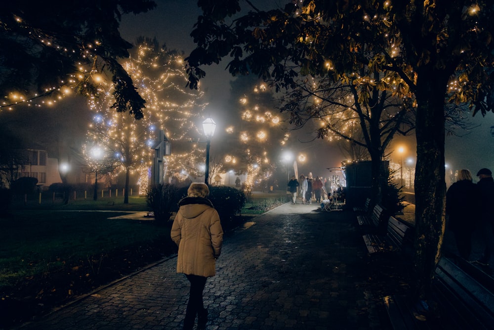 a woman walking down a street at night