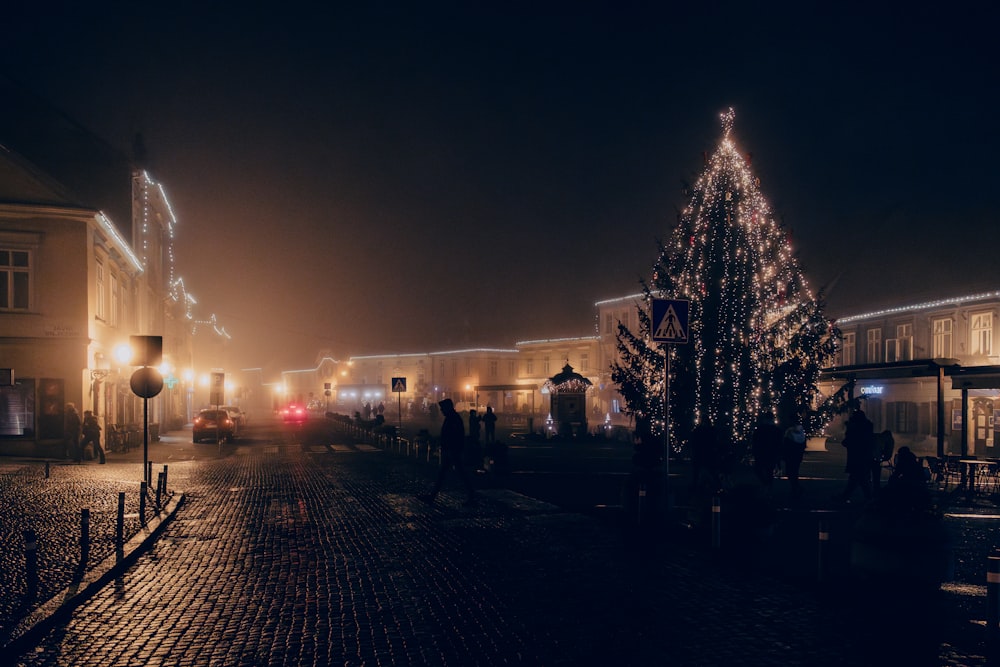 a lit up christmas tree on a city street