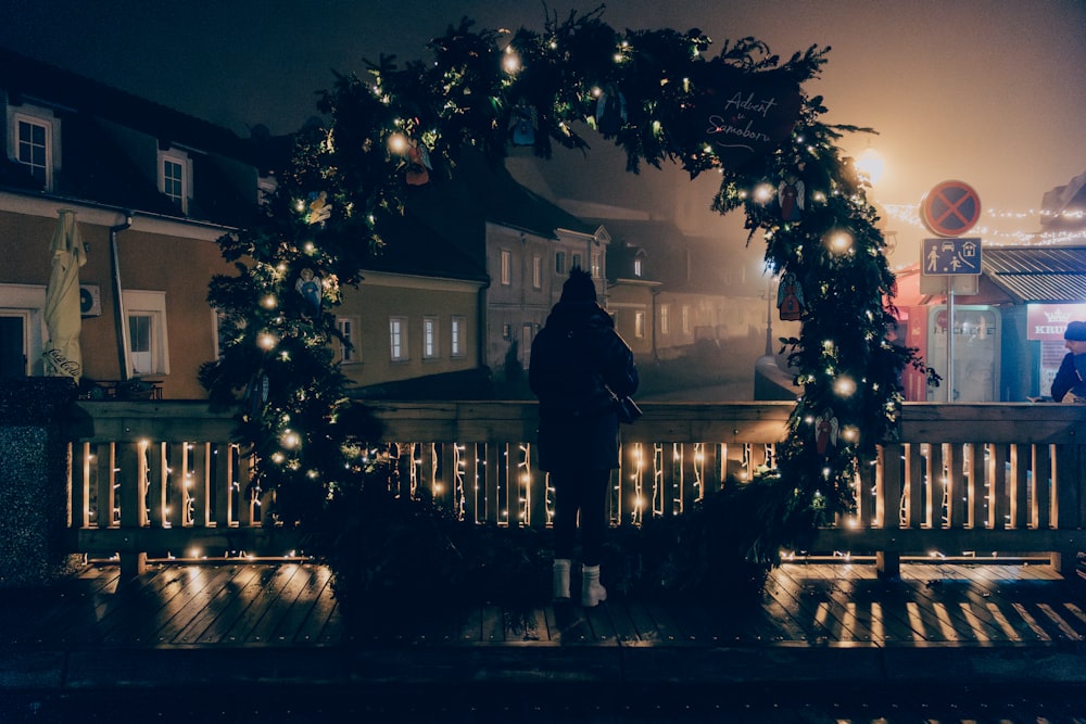 a person sitting on a bench in front of a christmas wreath